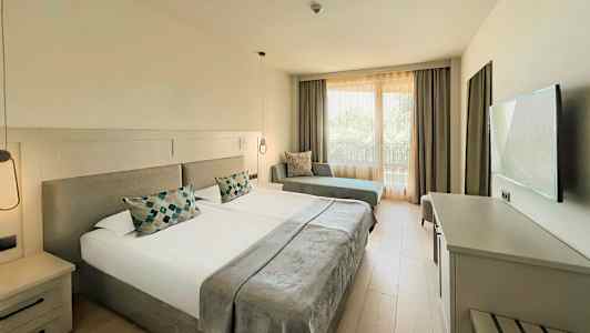 Huone hotellissa, jossa kaksi yhden hengen sänkyä, sohva ja televisio. (Tekoälyn luoma teksti)