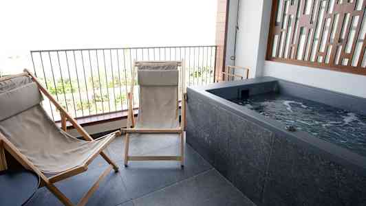 Terassi, jossa kaksi aurinkotuolia ja poreallas. (Tekoälyn luoma teksti)