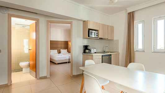 Huone, jossa keittiö ja ruokapöytä, makuuhuone ja kylpyhuone. (Tekoälyn luoma teksti)