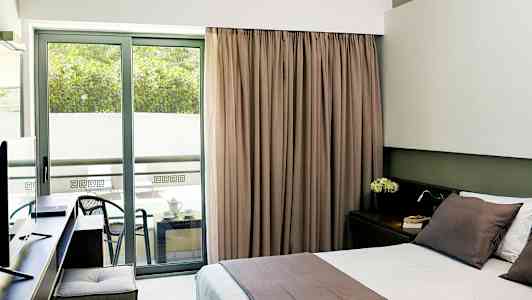 Hotellihuone, jossa on parivuode ja parveke istuinalueella. (Tekoälyn luoma teksti)