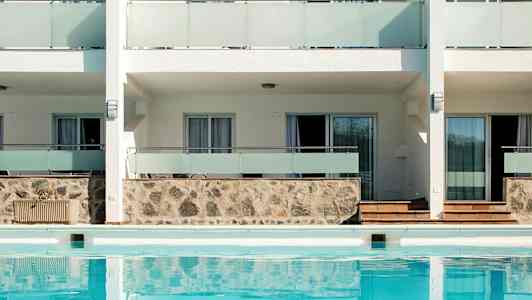 Rakennuksen ulkopuoli, edessä uima-allas. (Tekoälyn luoma teksti)