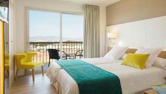 Hotellihuone, jossa kaksi sänkyä, tuoli ja parveke näkymällä. (Tekoälyn luoma teksti)