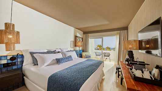 Hotellihuone, jossa suuri sänky, modernit sisusteet ja parveke näkymällä. (Tekoälyn luoma teksti)