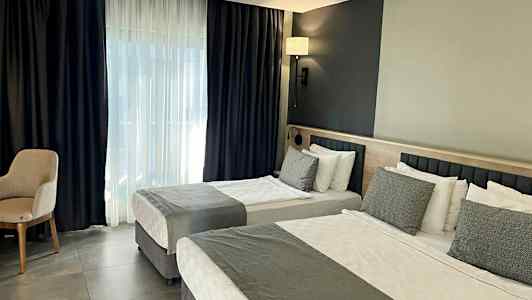 Hotellihuoneen sisustus kahdella sängyllä ja modernilla suunnittelulla. (Tekoälyn luoma teksti)