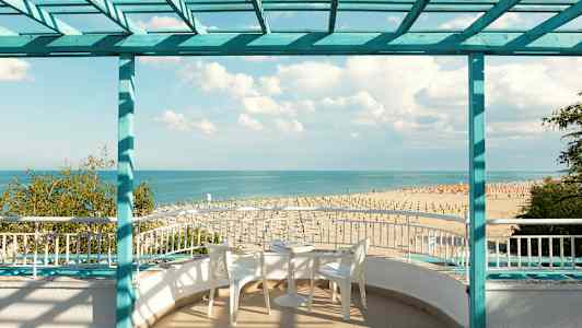 Näkymä rannalle ja merelle terassilta, jossa on istumapaikkoja. (Tekoälyn luoma teksti)