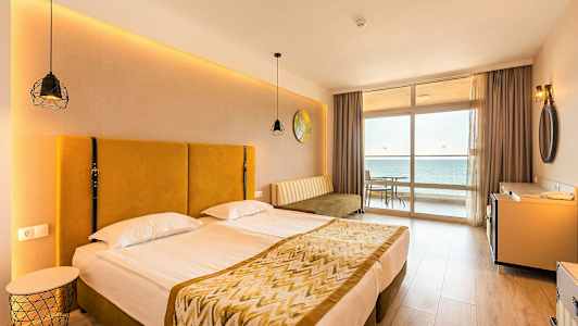 Kuva hotellihuoneesta, jossa on parivuode ja näkymä merelle ikkunasta. (Tekoälyn luoma teksti)