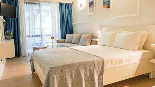 Hotellihuone, jossa suuri sänky, sohva ja pöytä. (Tekoälyn luoma teksti)