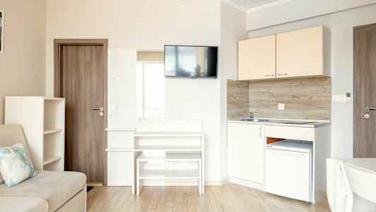 Pieni keittiö- ja oleskelutila, jossa on sohva, kaapit, TV ja keittiötarvikkeet. (Tekoälyn luoma teksti)