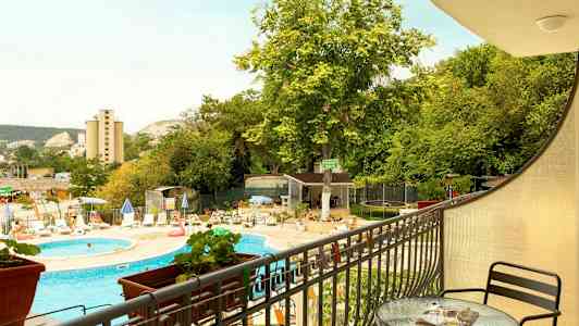 Näkymä parvekkeelta ulkouima-altaalle, aurinkotuoleille ja vehreyteen. (Tekoälyn luoma teksti)