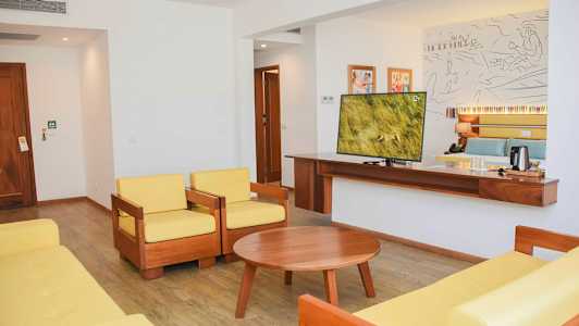 Hotellihuone, jossa oleskelutila ja televisio. (Tekoälyn luoma teksti)