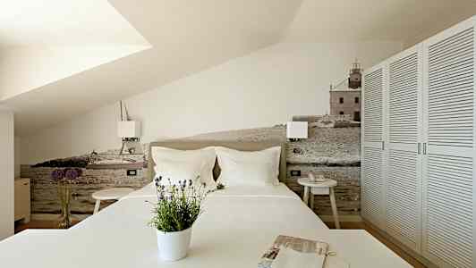 Makuuhuone, jossa on koristeellinen seinä, jossa on meri- ja rakennusaihe. (Tekoälyn luoma teksti)