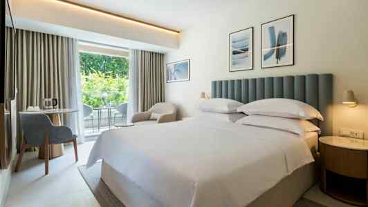 Hotellihuone, jossa on parivuode ja vaalea sisustus. (Tekoälyn luoma teksti)