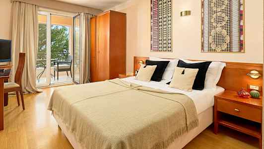 Parihuone, jossa parisänky, näkymä parvekkeelle istuimineen. (Tekoälyn luoma teksti)