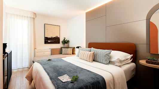 Moderni hotellihuone, jossa iso sänky, tyynyjä ja sisustuselementtejä. (Tekoälyn luoma teksti)