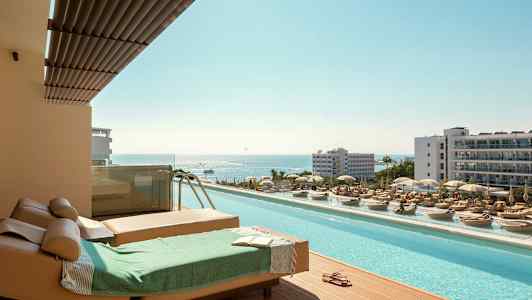 Aurinkotuolit ja uima-allas merinäköalalla lomakohteessa. (Tekoälyn luoma teksti)