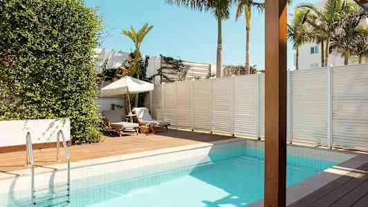 Uima-allas aurinkoterassilla ja aurinkotuoleilla trooppisessa ympäristössä. (Tekoälyn luoma teksti)