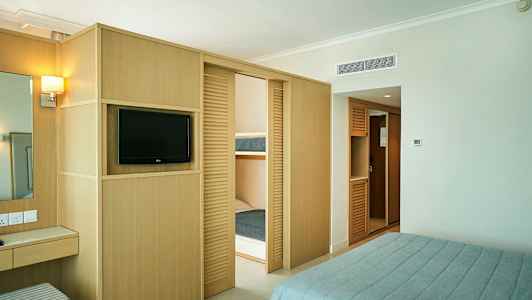 Hotellihuone, jossa televisio, vaatekaapit ja parivuode. (Tekoälyn luoma teksti)