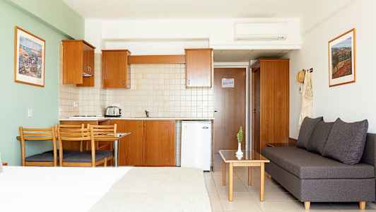 Hotellistudio, jossa keittiö, ruokapöytä ja istuinryhmä. (Tekoälyn luoma teksti)