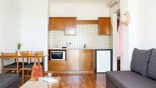 Pieni keittiö, jossa on puuhuonekalut ja valkoiset seinät. (Tekoälyn luoma teksti)