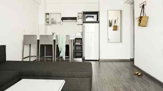 Modernisti sisustettu keittiö, jossa on istuinalue ja kalusteet. (Tekoälyn luoma teksti)