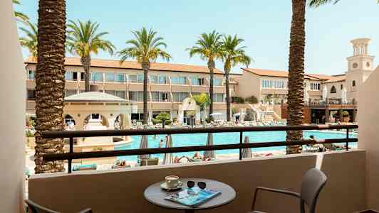 Näkymä parvekkeelta uima-altaalle ja ympäröiville hotellirakennuksille. (Tekoälyn luoma teksti)