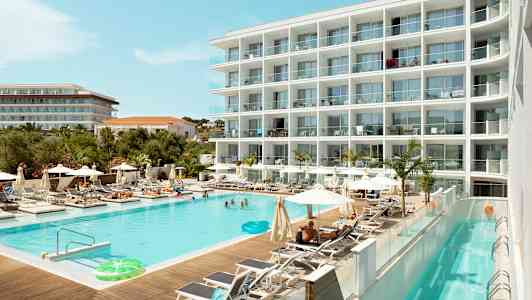 Hotelli, jossa on uima-allas aurinkotuolien ja aurinkovarjojen ympäröimänä. (Tekoälyn luoma teksti)