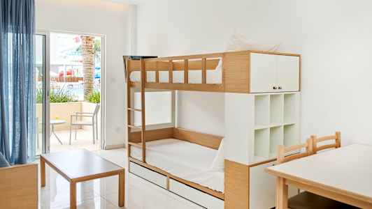 Kuva huoneesta, jossa on kerrossängyt, pöytä ja tuolit sekä ulkoterassi istuimilla. (Tekoälyn luoma teksti)