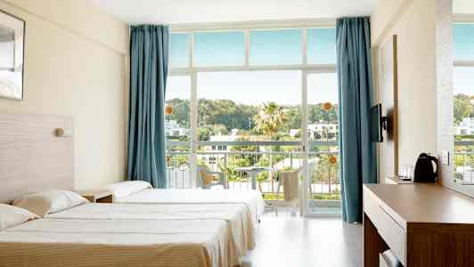 Hotellihuone, jossa on kaksi vuodetta, siniset verhot ja parveke näkymällä vehreyteen. (Tekoälyn luoma teksti)