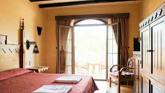 Hotellihuone, jossa on parisänky, pyyhkeitä, puukalusteet ja parveke, josta on näkymä. (Tekoälyn luoma teksti)