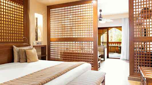 Hyvin kalustettu makuuhuone, jossa on koristeelliset puupaneelit, jotka erottavat olohuoneen. (Tekoälyn luoma teksti)