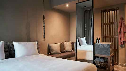 Makuuhuoneessa on suuri sänky, tyynyjä, sohva ja korkea peili. (Tekoälyn luoma teksti)