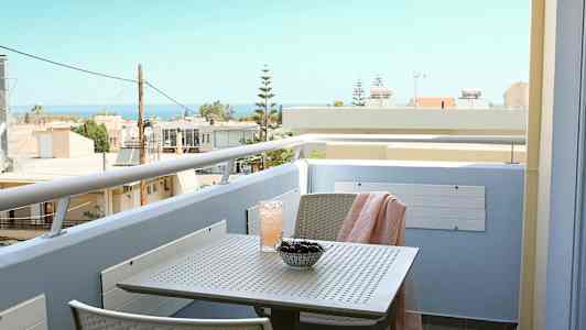 Parveke, jolta näkyy merelle, pöydällä on kirsikoita ja juoma. (Tekoälyn luoma teksti)