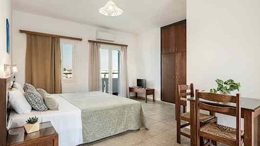 Makuuhuone, jossa on parivuode, pieni pöytä ja kaksi tuolia sekä vaatekaappi. (Tekoälyn luoma teksti)