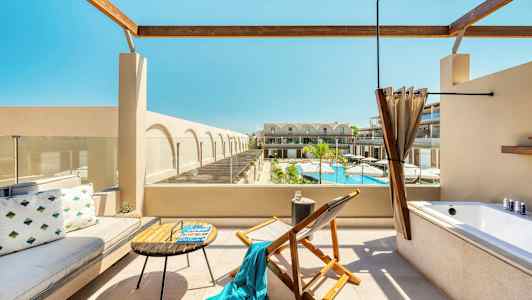 Terassi istuinkalusteilla, kylpyammeella ja näkymällä altaalle ja rakennuksiin. (Tekoälyn luoma teksti)