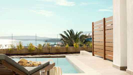 Aurinkotuoli uima-altaan äärellä, näkymä merelle. (Tekoälyn luoma teksti)