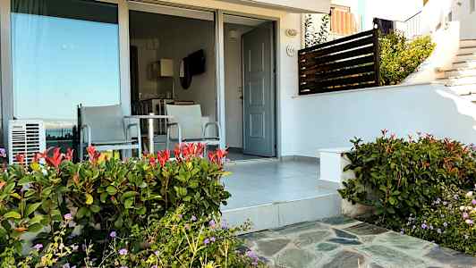 Terassi, jossa kaksi tuolia ja pöytä oven ja lasiseinän edessä. (Tekoälyn luoma teksti)