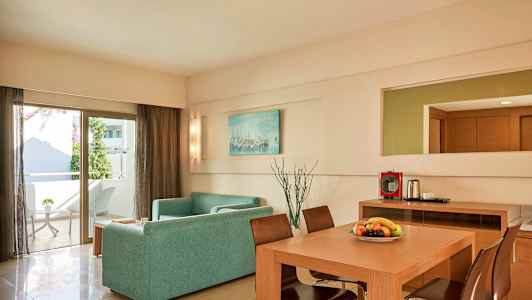 Nykyaikaisesti sisustettu olohuone, jossa on sohva, ruokapöytä ja tuolit. Ovi johtaa parvekkeelle. (Tekoälyn luoma teksti)