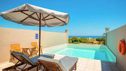 Pieni uima-allas aurinkotuoleilla ja aurinkovarjolla ulkona, näkymä merelle. (Tekoälyn luoma teksti)