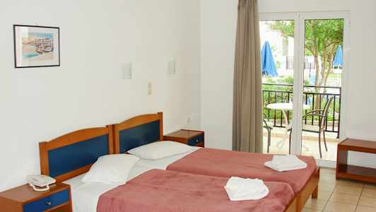 Kahden hengen huone, jossa sängyt, yöpöydät ja parveke ulkona. (Tekoälyn luoma teksti)