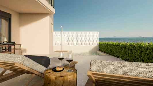 Kuva terassista, jossa on aurinkotuoleja, pöytä viinilaseilla ja näkymä merelle. (Tekoälyn luoma teksti)