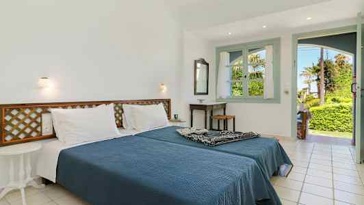 Makuuhuone, jossa parisänky, pöytä ja avoin ovi vehreään puutarhaan. (Tekoälyn luoma teksti)