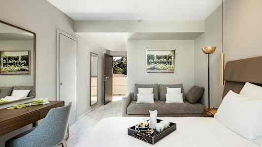 Hotellihuone, jossa sänky, sohva ja kirjoituspöytä. (Tekoälyn luoma teksti)