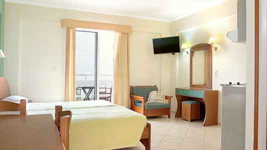 Hotellihuone, jossa kaksi vuodetta, istuin ja kirjoituspöytä. Lisäksi on parveke kalusteilla. (Tekoälyn luoma teksti)