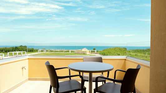 Parveke, jossa pöytä ja tuolit, merinäköala. (Tekoälyn luoma teksti)