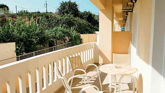 Parveke puutarhan näkymällä, varustettu pöydällä ja tuoleilla. (Tekoälyn luoma teksti)