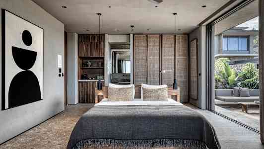Moderni makuuhuone, jossa suuri sänky ja avoin lasiseinä avautuu terassille. (Tekoälyn luoma teksti)