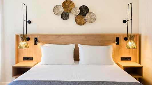 Sänky, jossa kaksi tyynyä ja koristeita seinällä. (Tekoälyn luoma teksti)