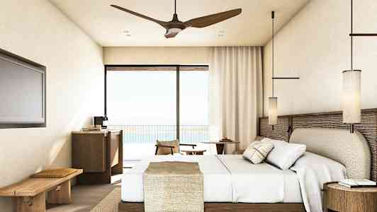 Hotellihuone, jossa on sänky, huonekaluja ja parvekkeen ovi näkymällä. (Tekoälyn luoma teksti)