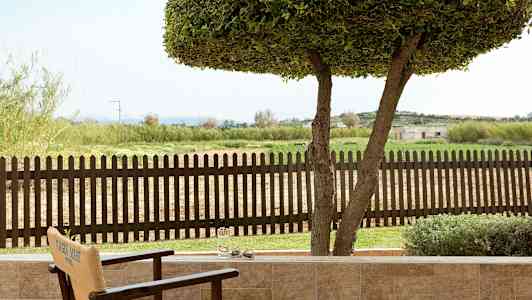 Näkymä terassilta puuaitaan ja vihreään maisemaan. (Tekoälyn luoma teksti)