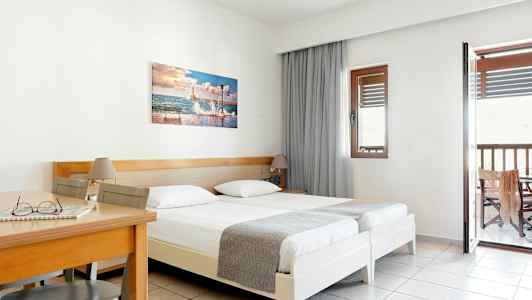 Hotellihuone, jossa kaksi erillistä vuodetta, puupöytä ja tuoli sekä parveke. (Tekoälyn luoma teksti)